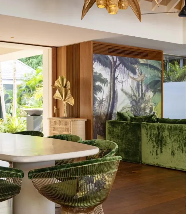 villa dining room with green velvet chairs and light dining table
