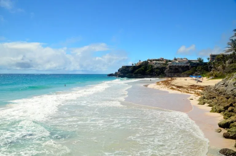 Crane Beach in Barbados with ocean waves and cliffs on each side of the beach. 