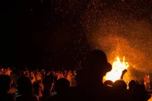 A crowd gathers around the bonfire at Shell Beach