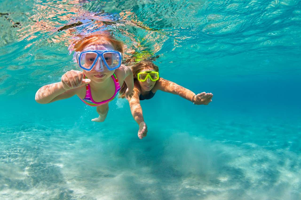 mother with child swim underwater with fun in sea